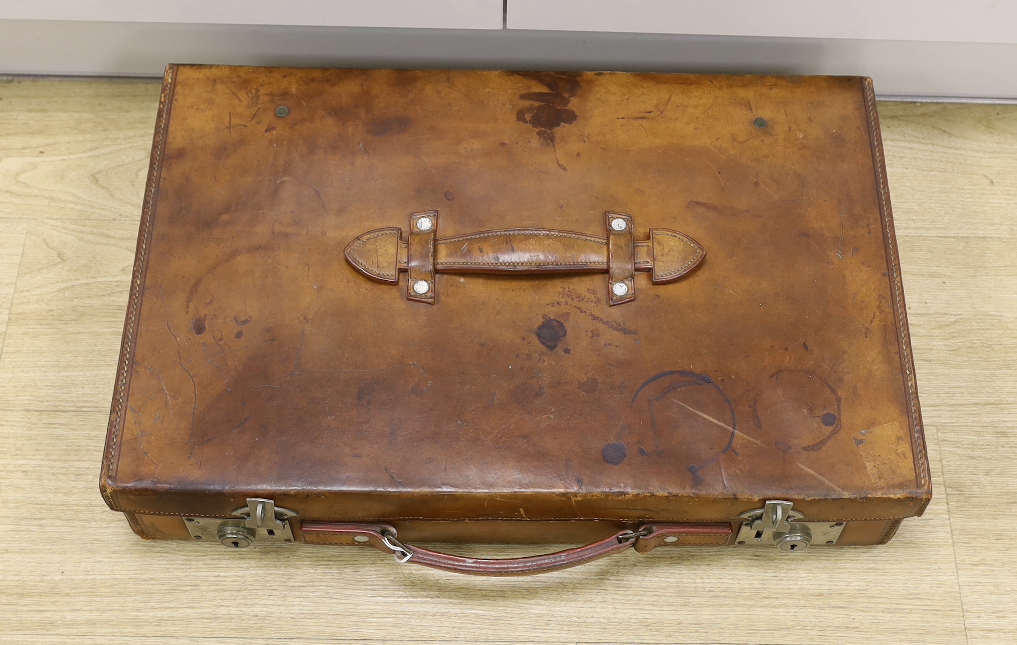 An early 20th century Hardy Bros. Alnwick tan leather fishing reel case, 58cm max.